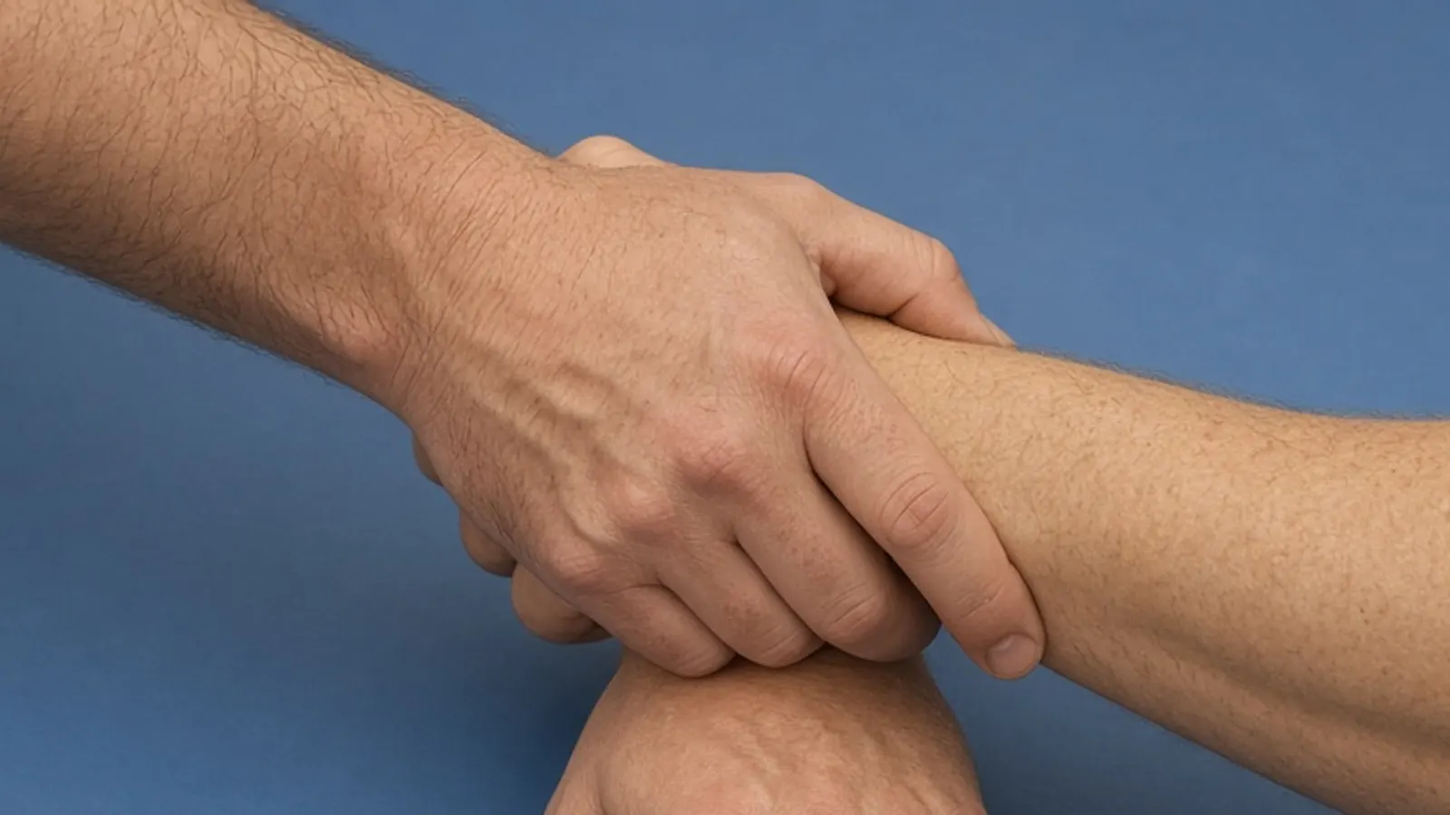 One hand closes around another wrestler's wrist.